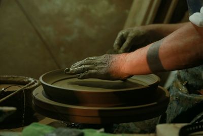 Cropped hands of man making container in workshop