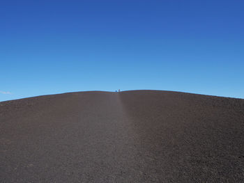 Scenic view of desert against clear blue sky