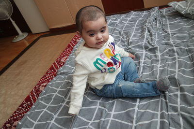 High angle view of cute baby on bed at home