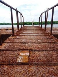 Footpath by railing against sky
