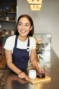 Portrait of young woman sitting on table