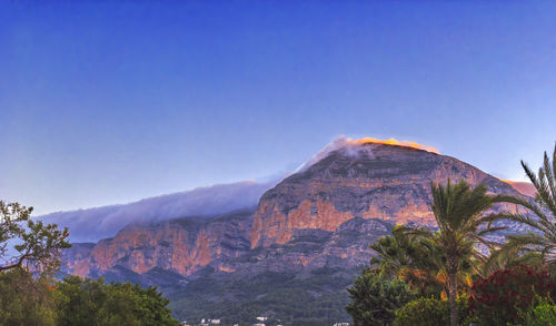 Scenic view of mountains against clear blue sky