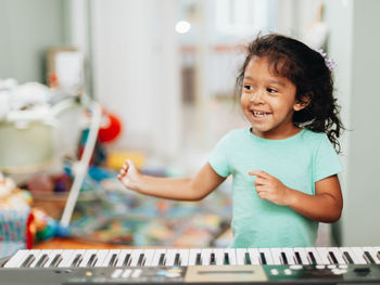 Cute girl learning piano at home