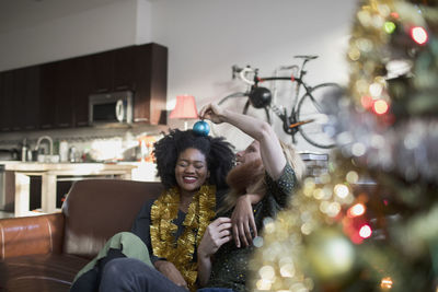 A young couple by a christmas tree