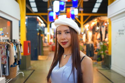 Portrait of woman standing in illuminated store