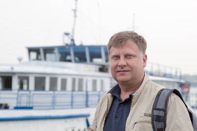 An adult male sailor with a backpack returned home after a long voyage.