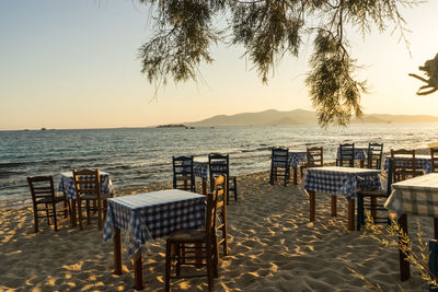 Empty chairs and tables at beach