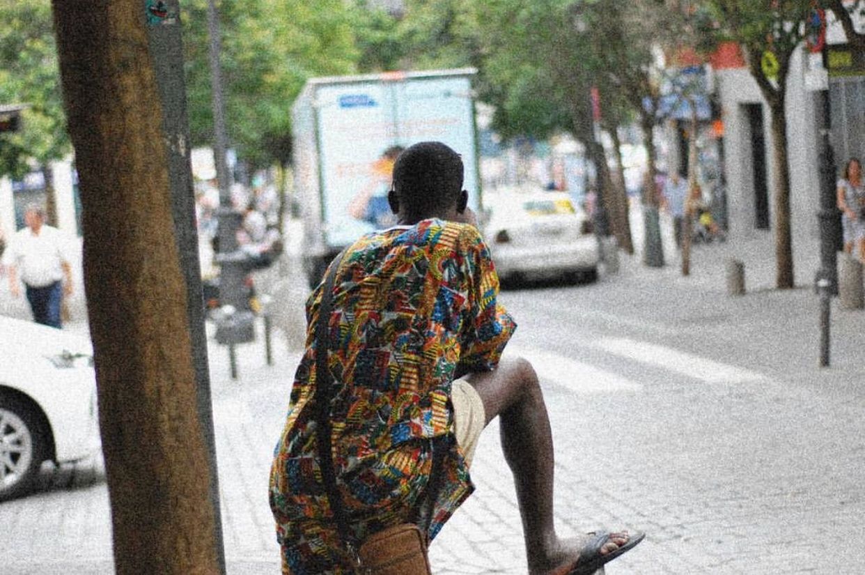 REAR VIEW OF MAN WALKING ON STREET