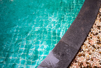 Bright blue water and the black granite edge of the swimming pool