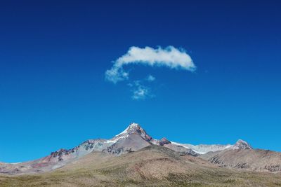 Scenic view of mountains against blue sky