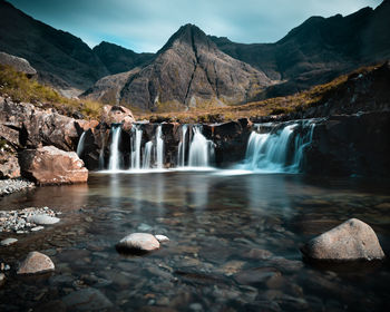 Scenic view of waterfall against sky