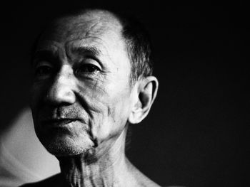 Close-up portrait of senior man in darkroom