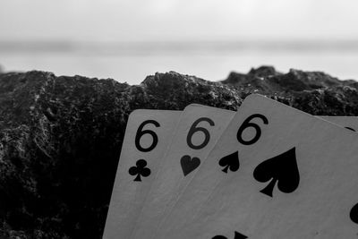 Close-up of text on rock at beach against sky