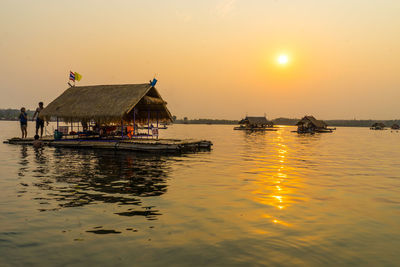 Floating huts on sea at sunset