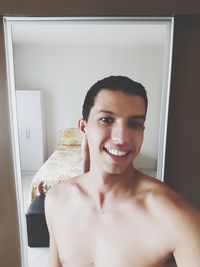 Portrait of shirtless man smiling at home