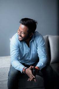 Man looking away while sitting on sofa