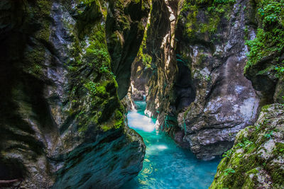 View of stream along rocky cliff