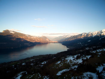 Scenic view of lake and mountains against clear sky