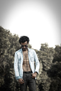 Young man standing against sky