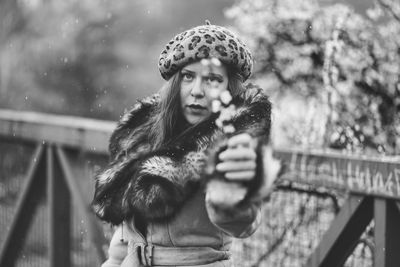 Portrait of woman holding twig outdoors