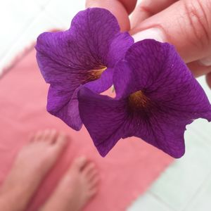 Cropped image of purple holding flower