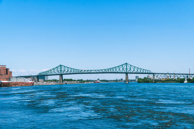 View of bridge over sea against clear blue sky