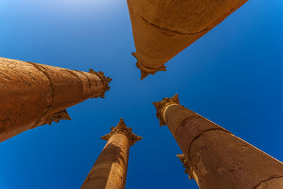 Low angle view of columns against clear blue sky