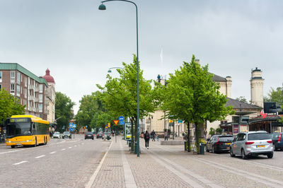 Cars on city street against sky