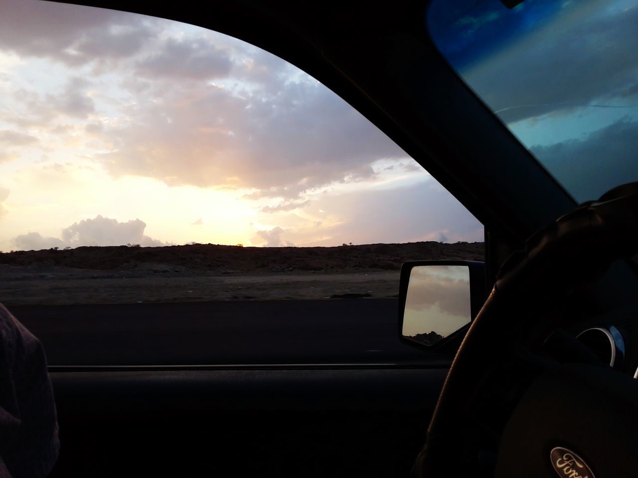 sky, transportation, cloud - sky, sunset, mode of transport, land vehicle, car, vehicle interior, cloud, cloudy, window, beauty in nature, sun, scenics, part of, nature, glass - material, road, sunlight, transparent