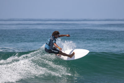 Man surfing in sea against sky