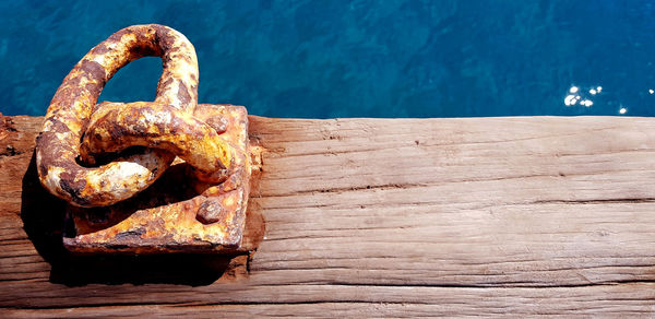 High angle view of rusty chain on pier at sea