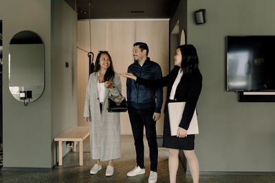 Real estate agent showing house to smiling couple