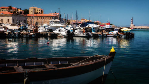 Boats moored in harbor against buildings in city