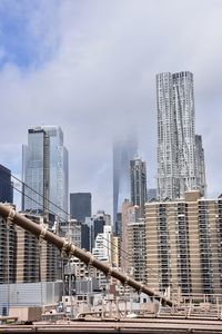 Modern buildings in city against sky in clouds