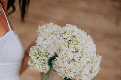 Close-up of woman holding white flower bouquet