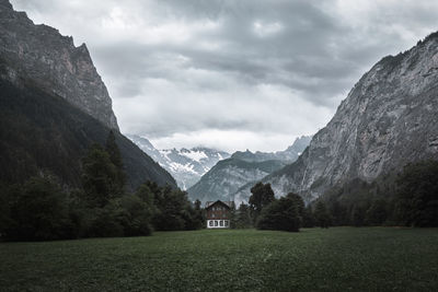 Scenic view of house and mountains against sky