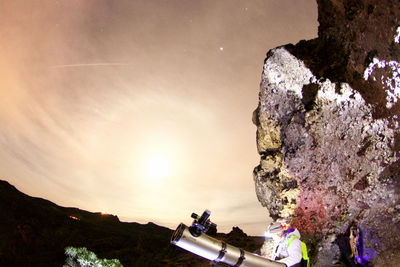 People on rock formations against sky