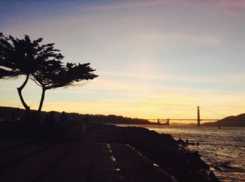 Bridge over river at sunset