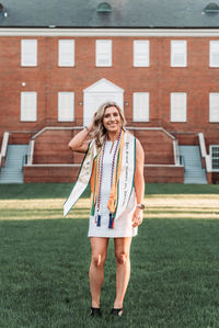 Portrait of smiling woman standing against building