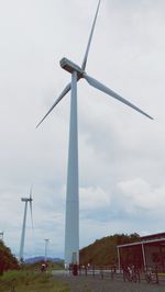 Low angle view of windmill on field against sky