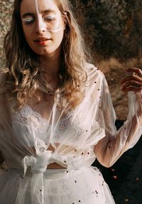 Young woman with eyes closed standing outdoors