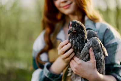 Midsection of woman holding bird
