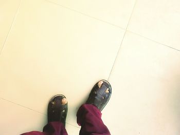 Low section of person standing on tiled floor