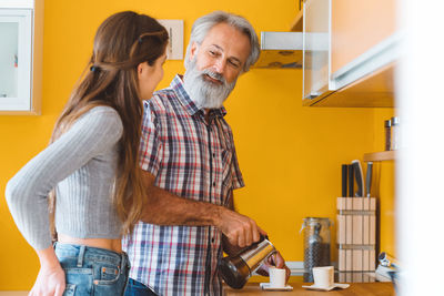 Side view of young man standing at home