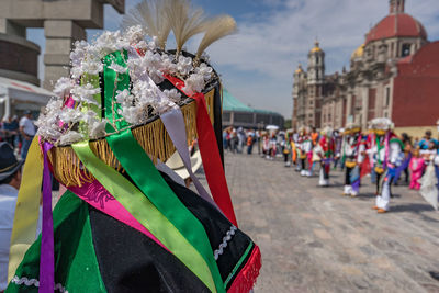 People in costume performing on street in city during traditional festival