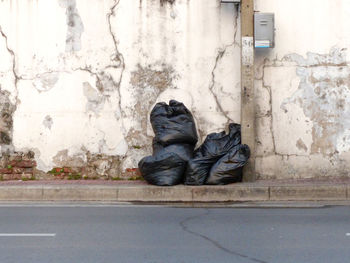 Garbage bags against weathered wall