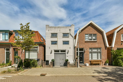 Street amidst houses against sky