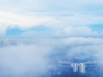 Aerial view of buildings in city against sky