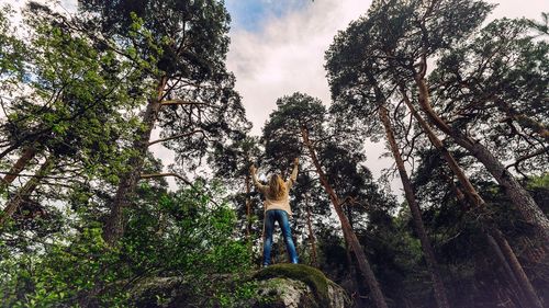 Full length of woman standing on tree trunk