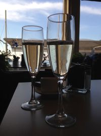 Close-up of wine glasses on table against sky